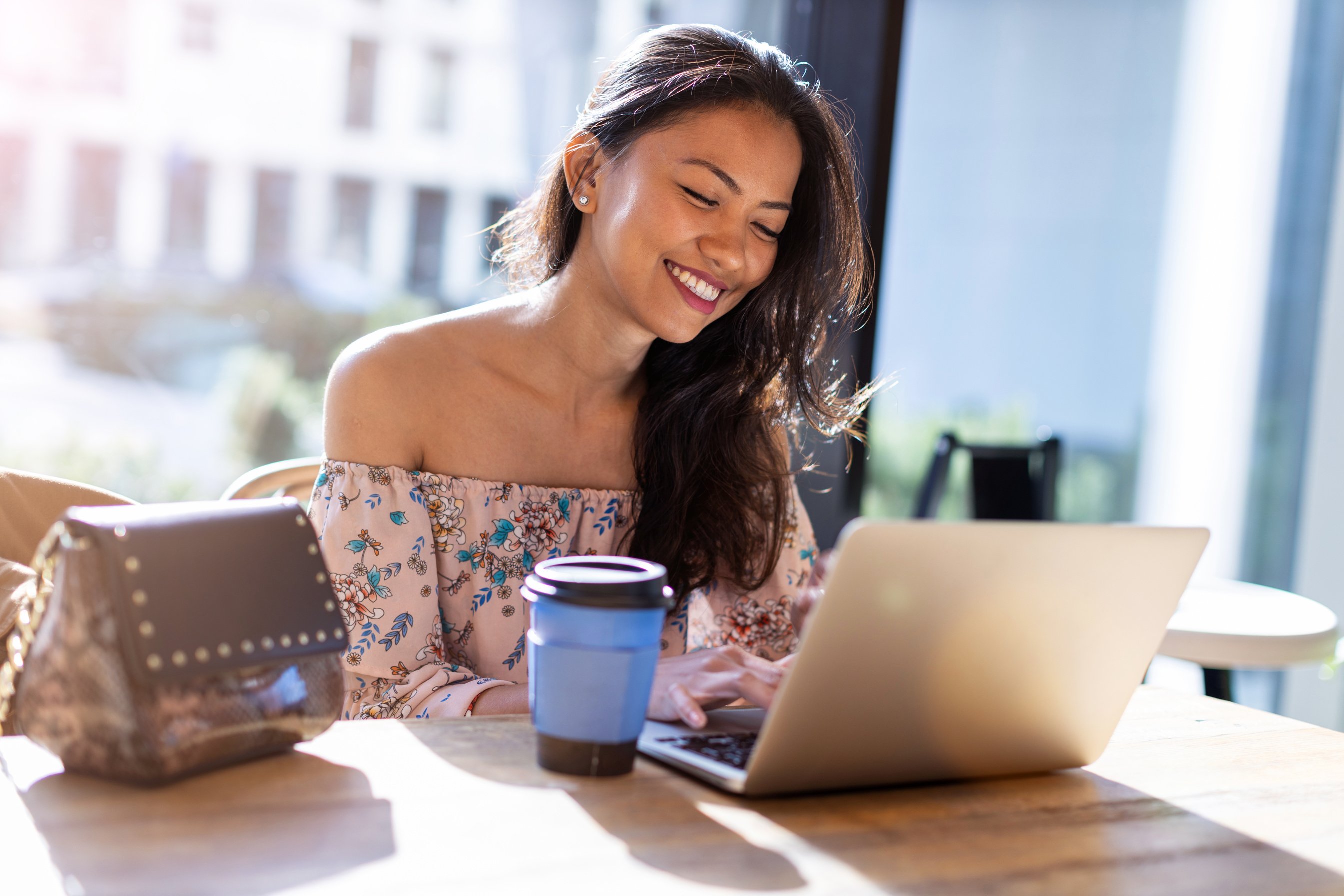 Beautiful Filipino woman using laptop at cafe