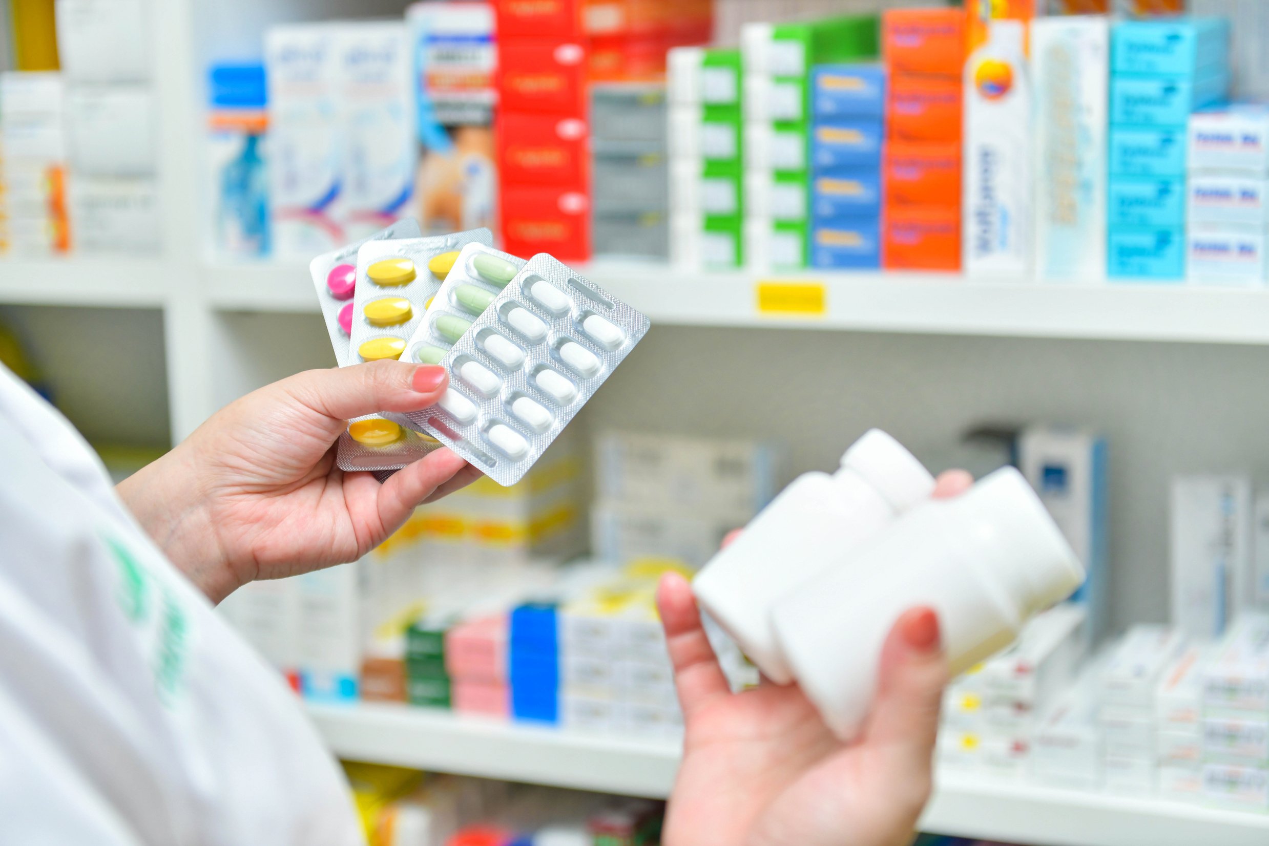 Pharmacist holding medicine pack and medicine bottle